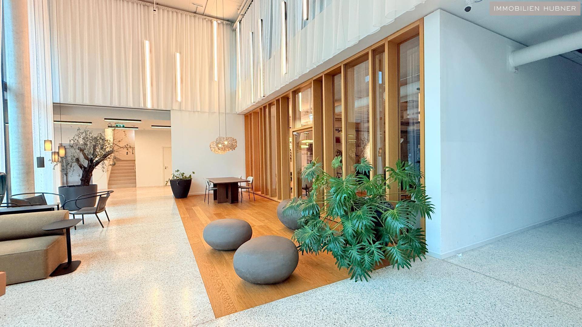 Elegante Lobby mit hohen Decken, großen Fenstern und modernen Sitzgelegenheiten.