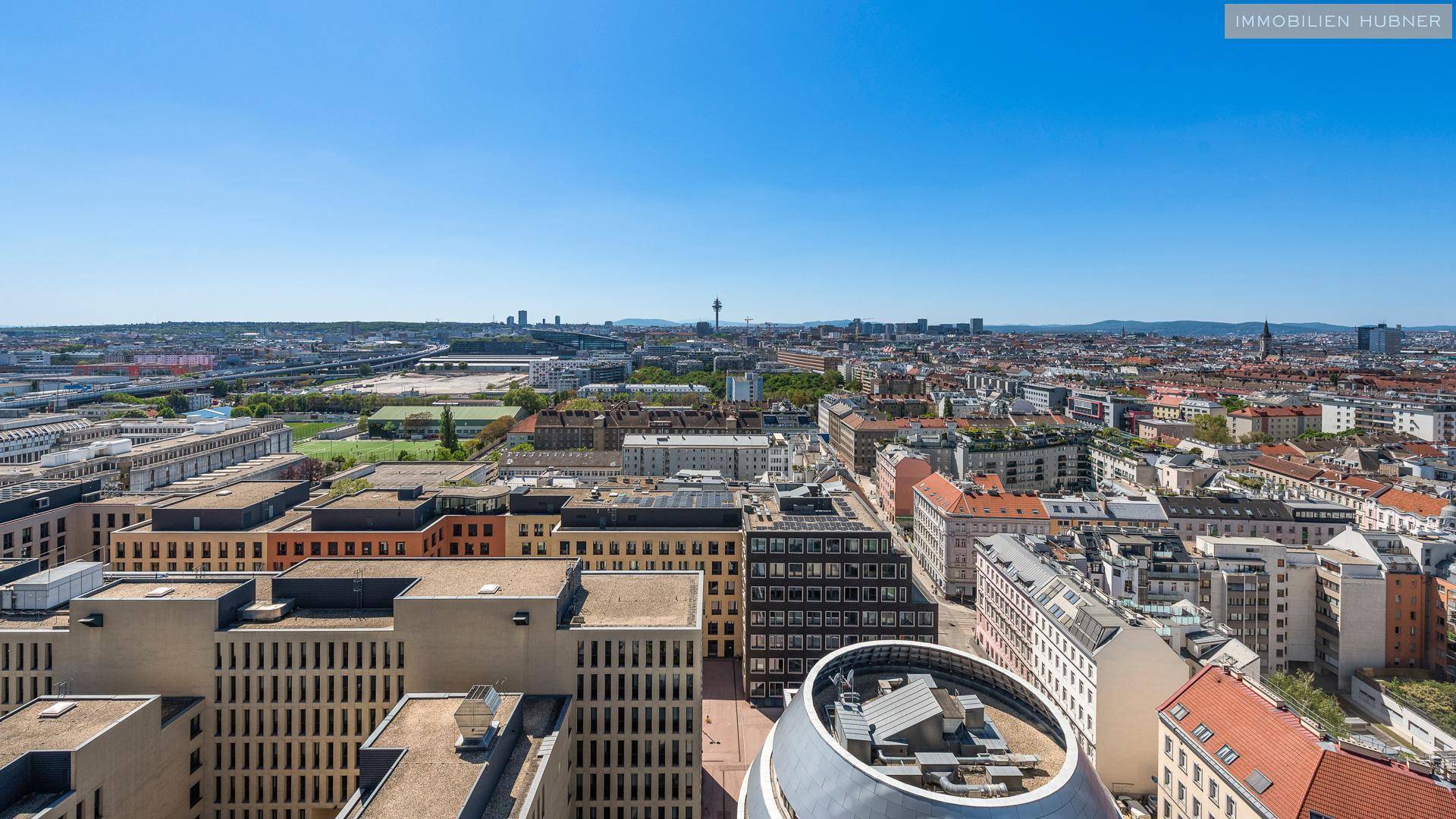 Weitläufiger Blick über die städtische Bebauung mit verschiedenen Gebäudetypen und Infrastruktur.