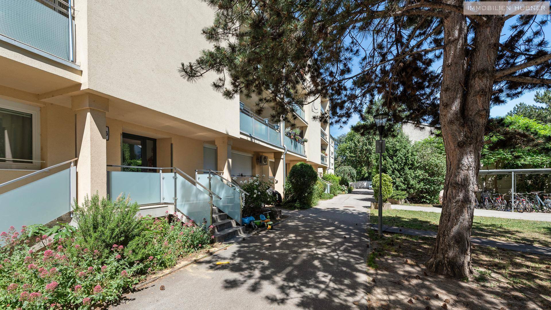 Erdgeschoss des Mehrfamilienhauses mit Eingängen und einem gepflegten Gehweg.