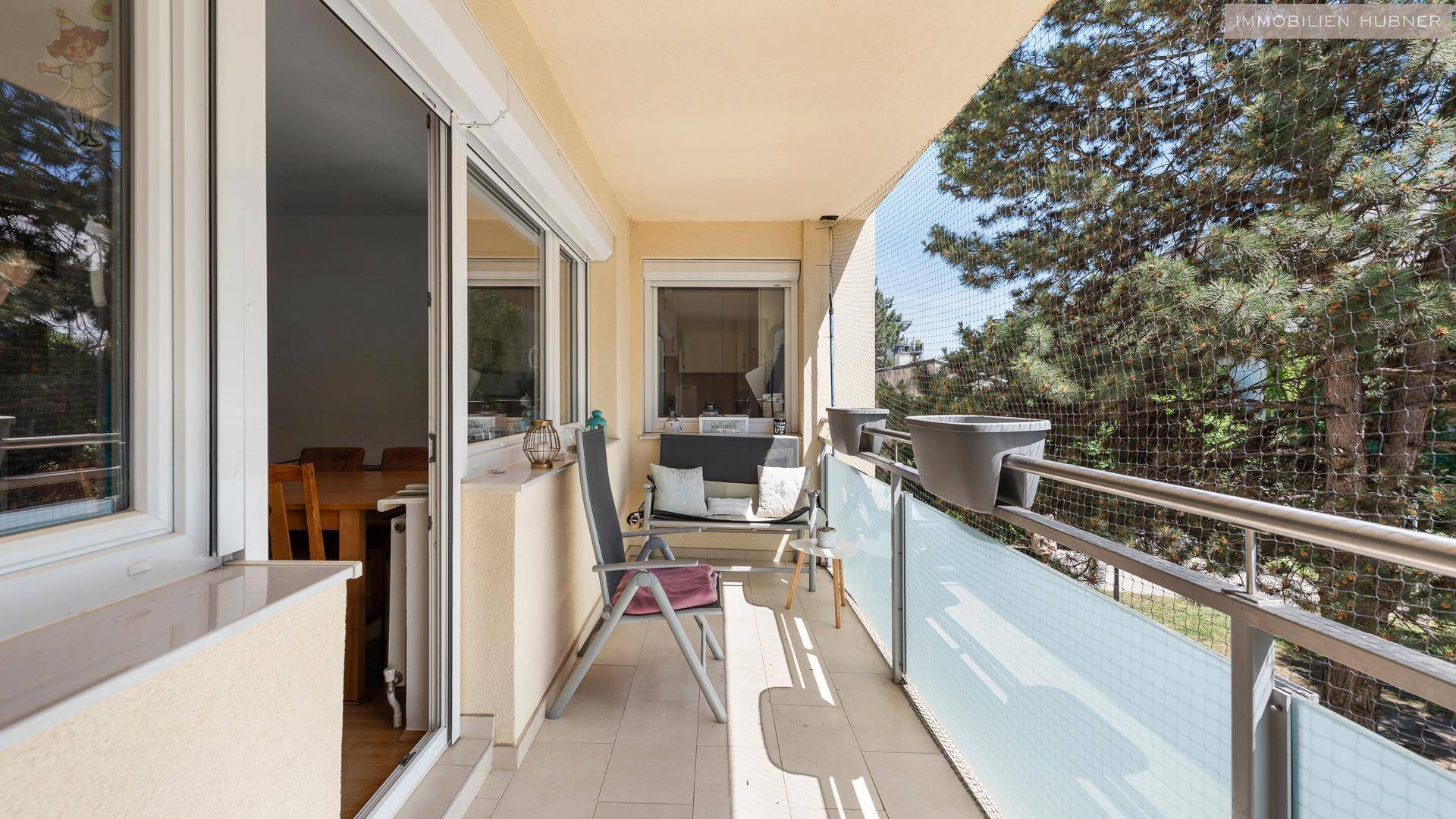 Gemütlicher Balkon mit Sitzgelegenheiten und Blick ins Grüne, ausgestattet mit einem Schutznetz.