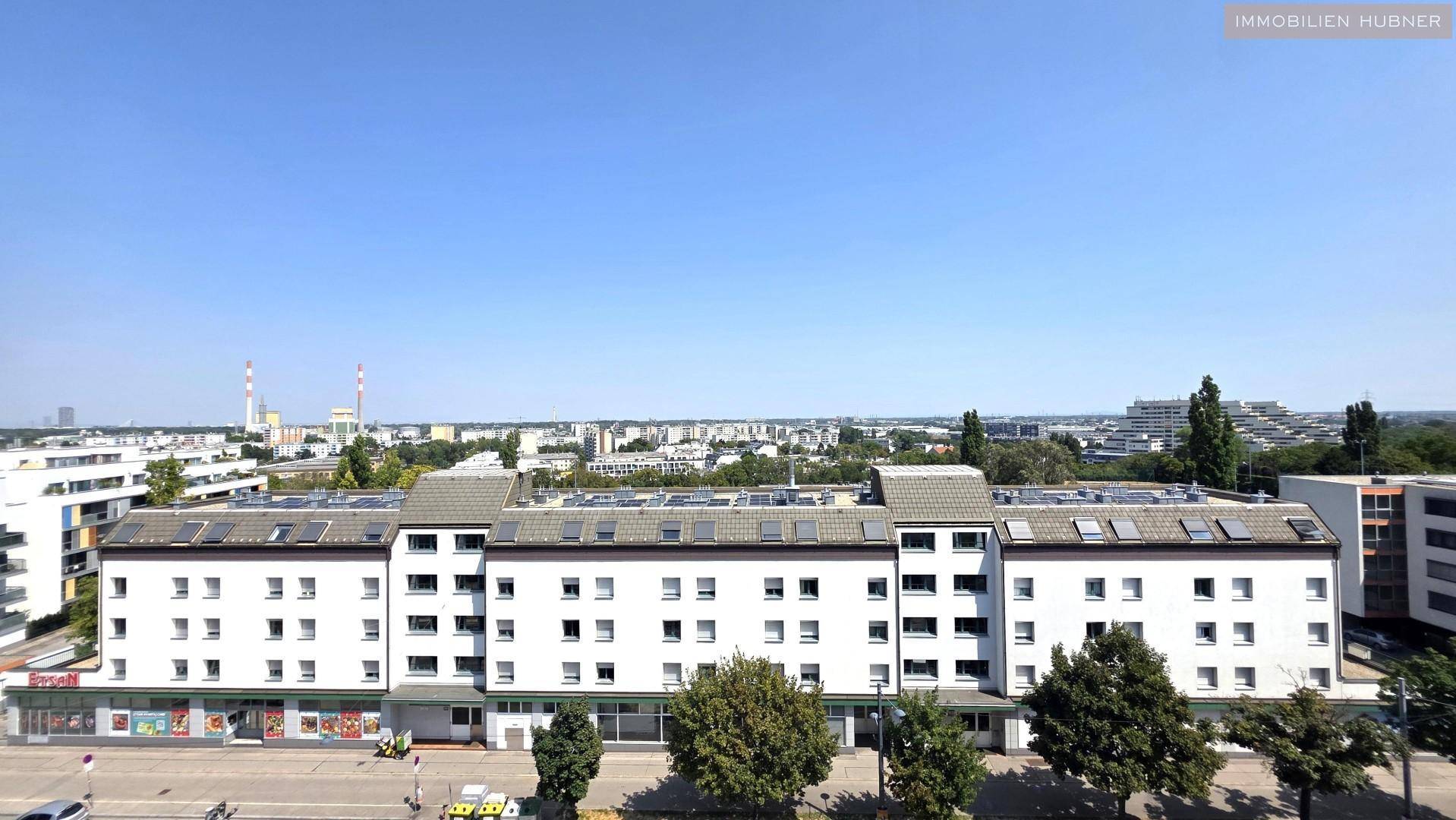 Ansicht eines Wohngebäudes mit vielen Fenstern und Solarpaneelen auf dem Dach.