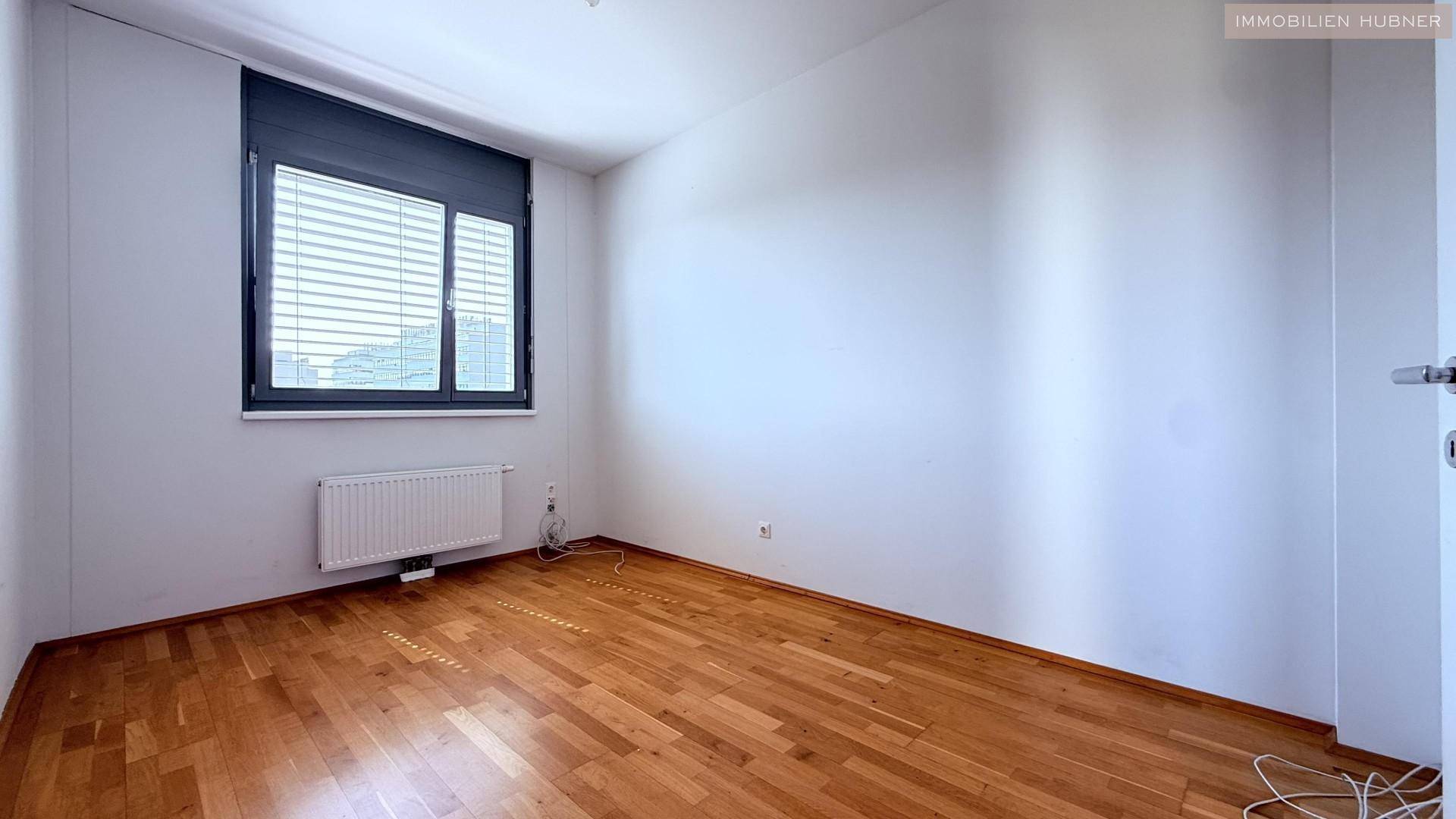 Ruhiges Schlafzimmer mit Holzboden und einem Fenster, ideal für erholsamen Schlaf.