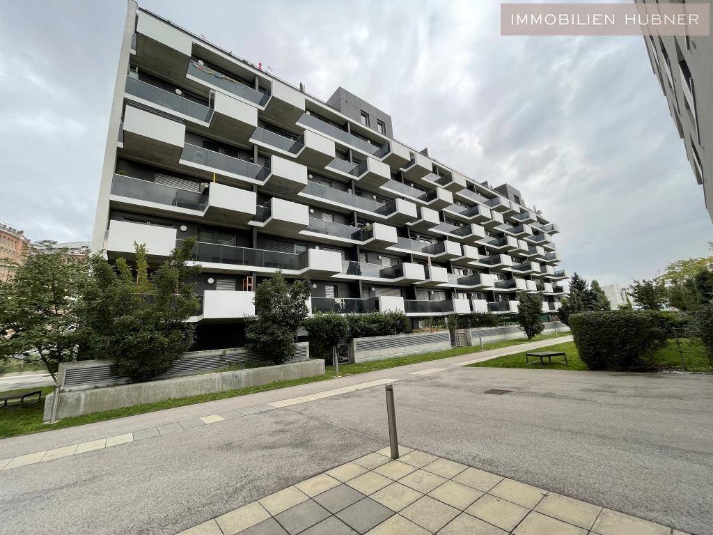 Modernes Mehrfamilienhaus mit vielen Balkonen und einer ansprechenden Fassadengestaltung.