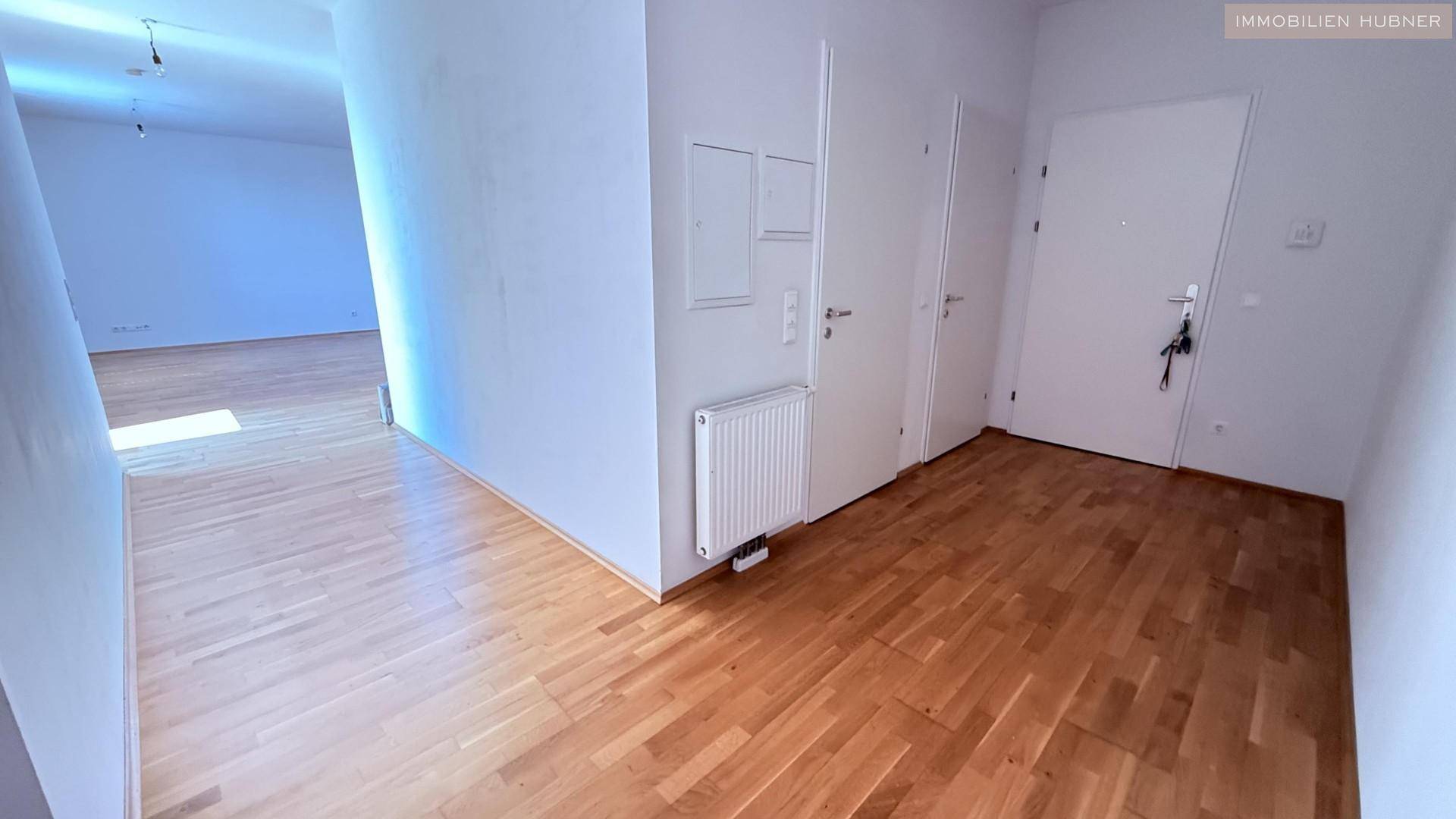 Heller Eingangsbereich mit Parkettboden und Zugang zu verschiedenen Räumen der Wohnung.