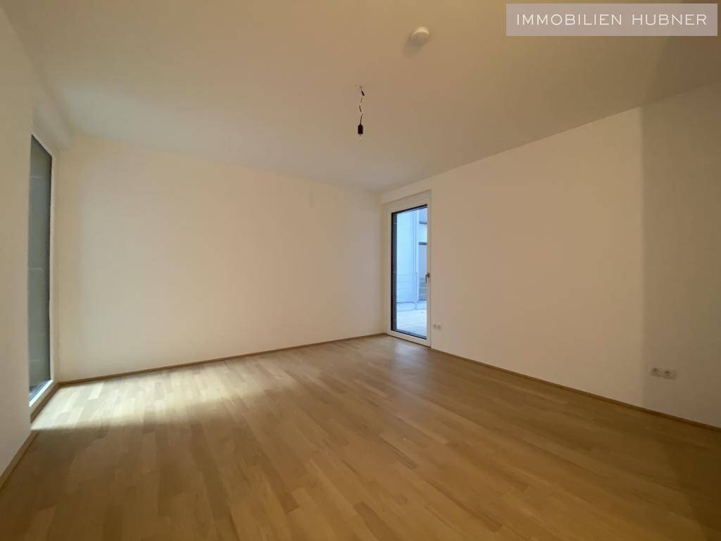 Helles Zimmer mit Parkettboden und Zugang zur Terrasse, vielseitig nutzbar.