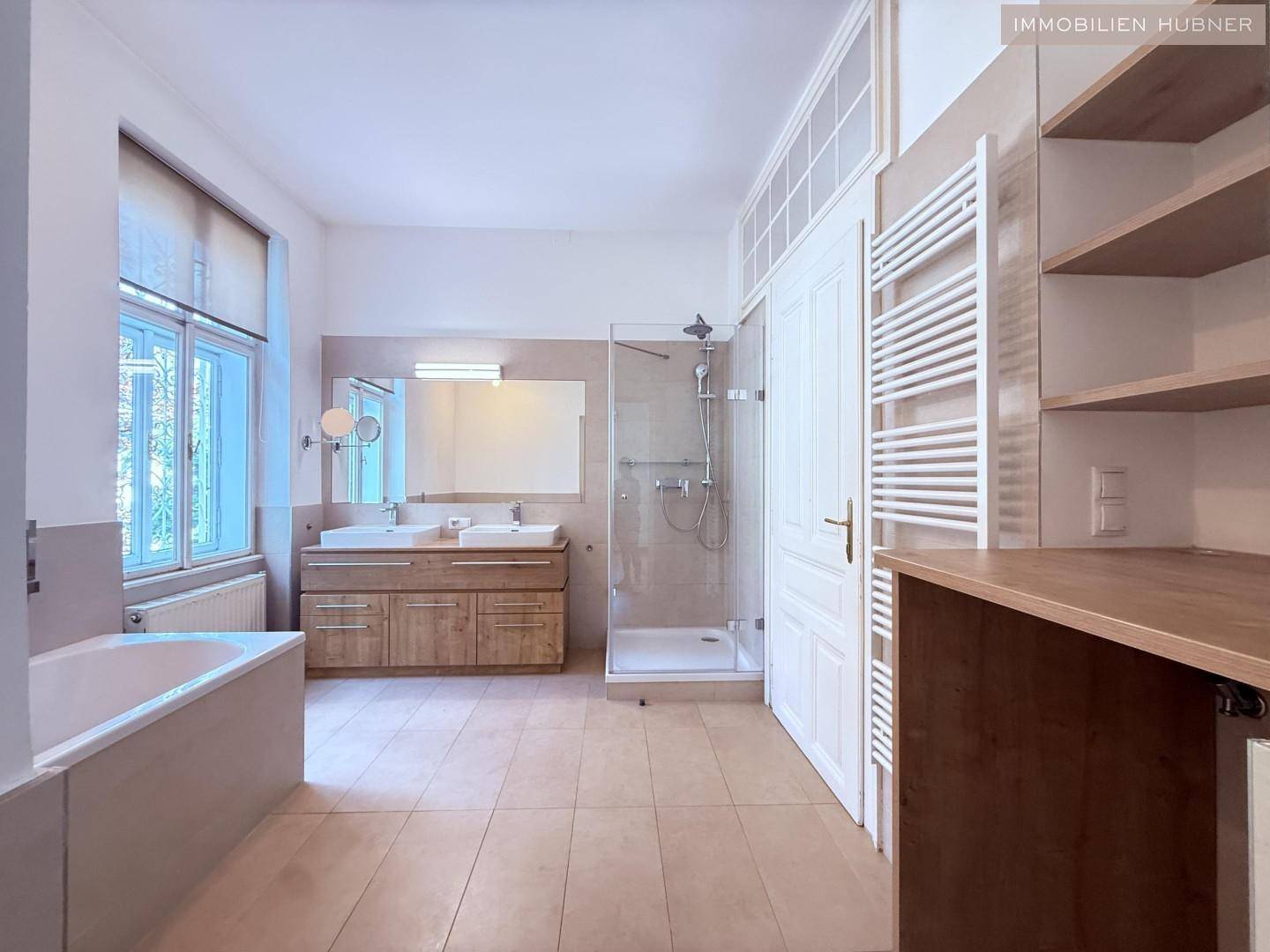 Geräumiges Badezimmer mit Doppelwaschbecken, Badewanne und begehbarer Dusche.