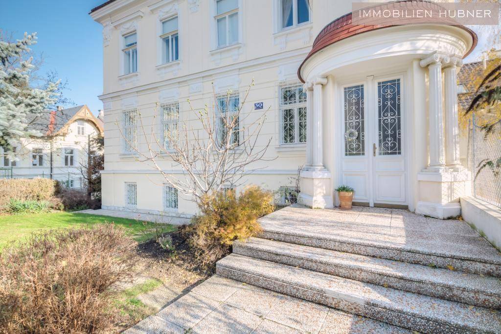 Prunkvoller Eingangsbereich des Gebäudes mit Säulen und breiter Steintreppe.