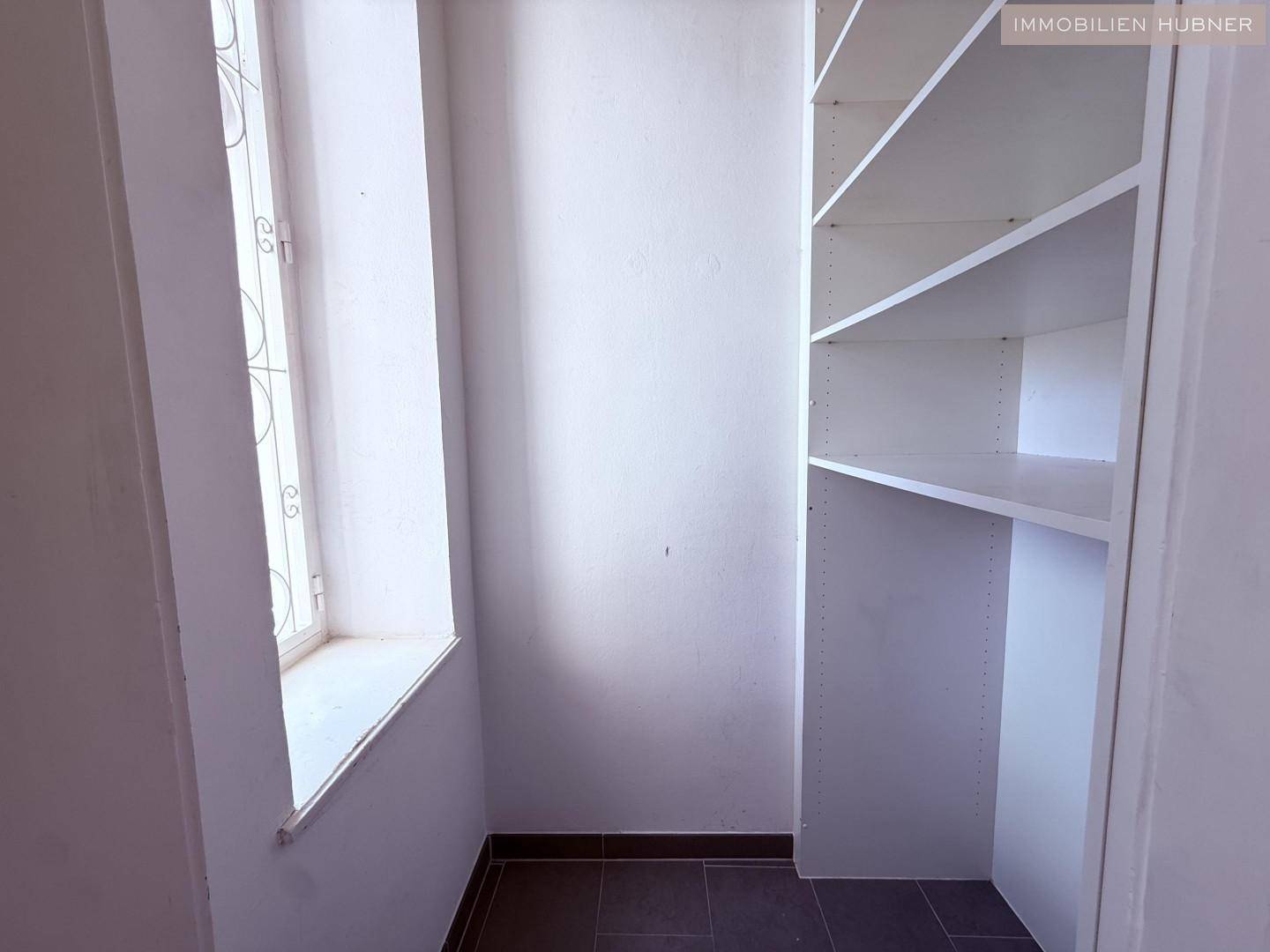 Praktischer Abstellraum mit eingebauten Regalen und Fenster für natürliche Belüftung.