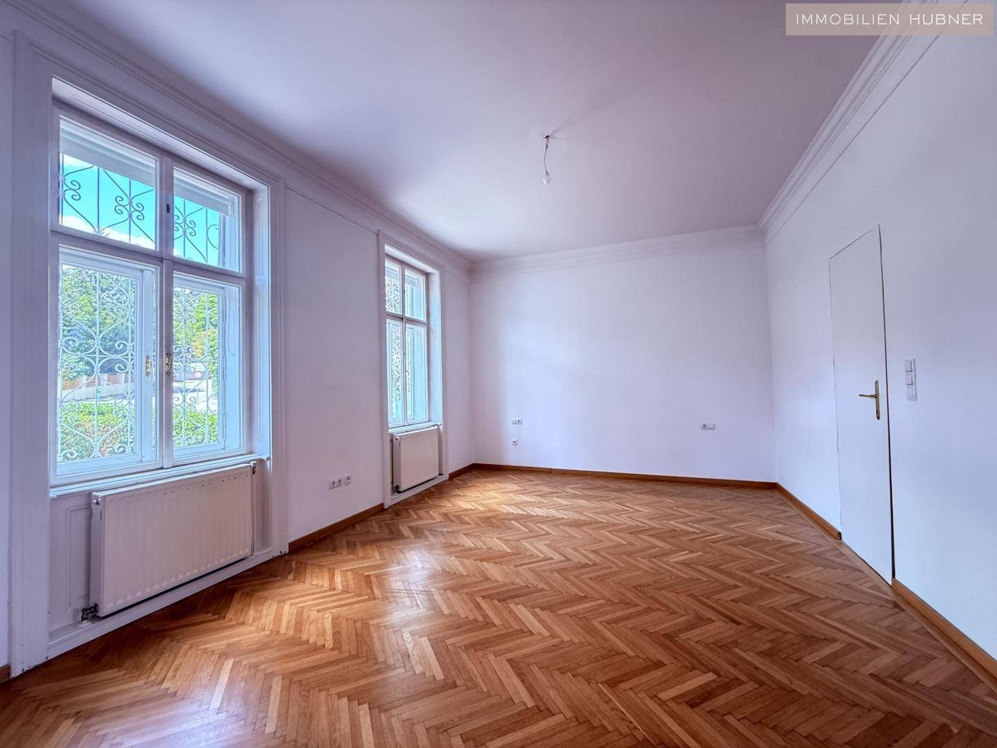 Helles Zimmer mit Fischgrätparkett und hohen Decken, bereit zur individuellen Gestaltung.