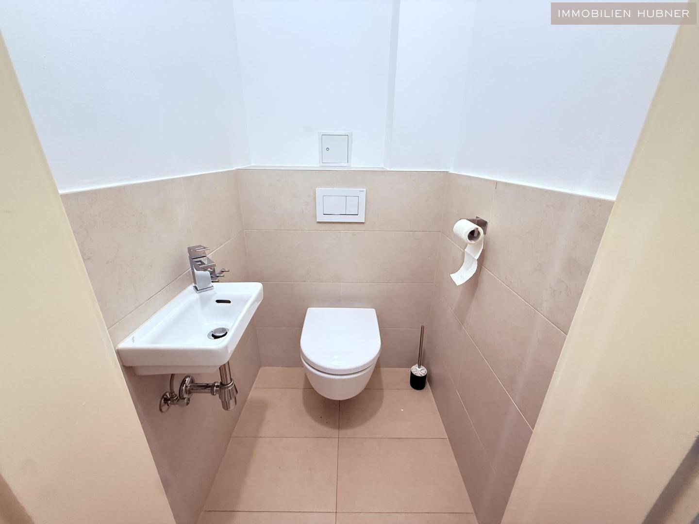 Kleines Gäste-WC mit modernem Wand-WC und kompaktem Waschbecken.