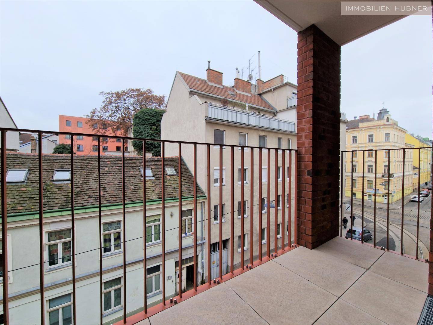 Balkon mit Blick auf die umliegenden Gebäude und die belebte Straße.