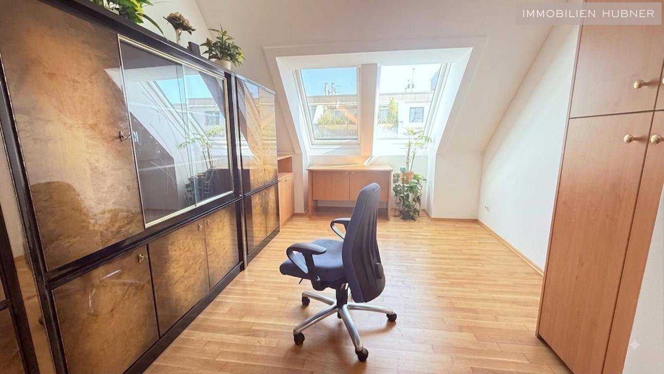 Helles Arbeitszimmer mit Parkettboden, Dachschrägen und großen Dachfenstern für viel Tageslicht.