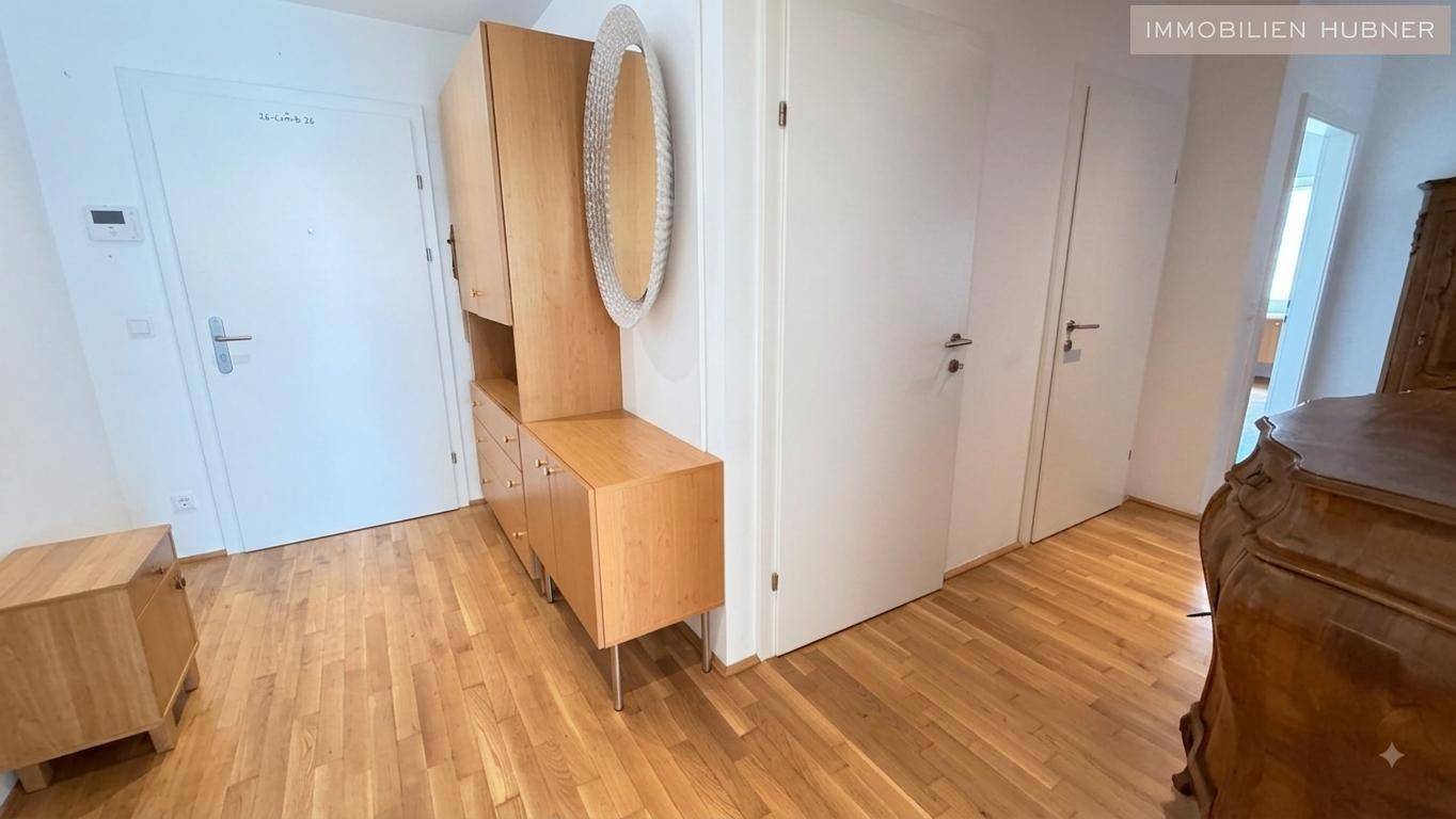 Heller Flur mit Parkettboden und praktischen Holzmöbeln, die Stauraum und eine Spiegelfläche bieten.