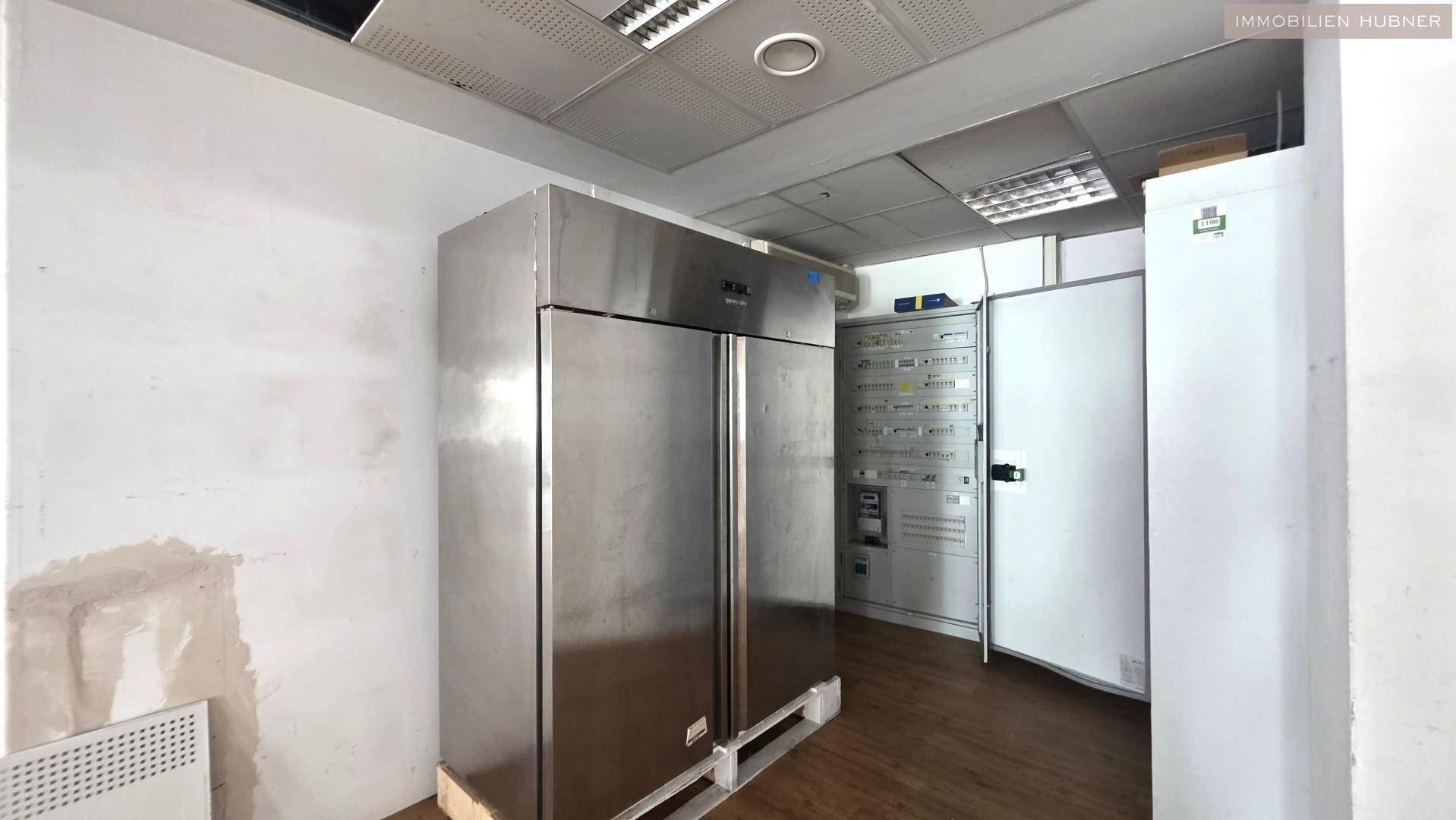 Lagerraum mit großen Edelstahlkühlschränken und elektrischen Schalttafeln an der Wand.