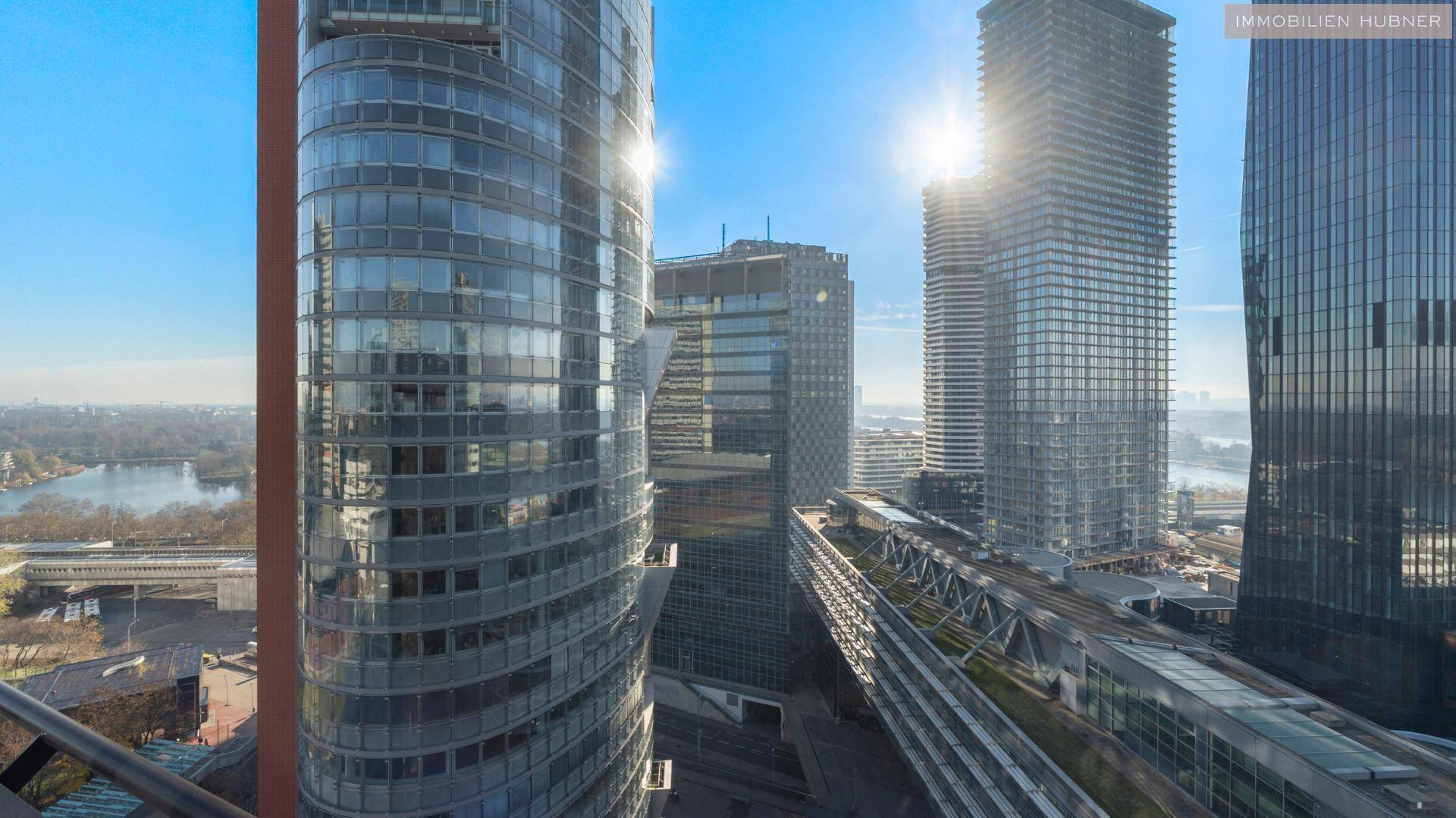 Sonniger Ausblick auf moderne Wolkenkratzer und die städtische Skyline unter strahlend blauem Himmel.