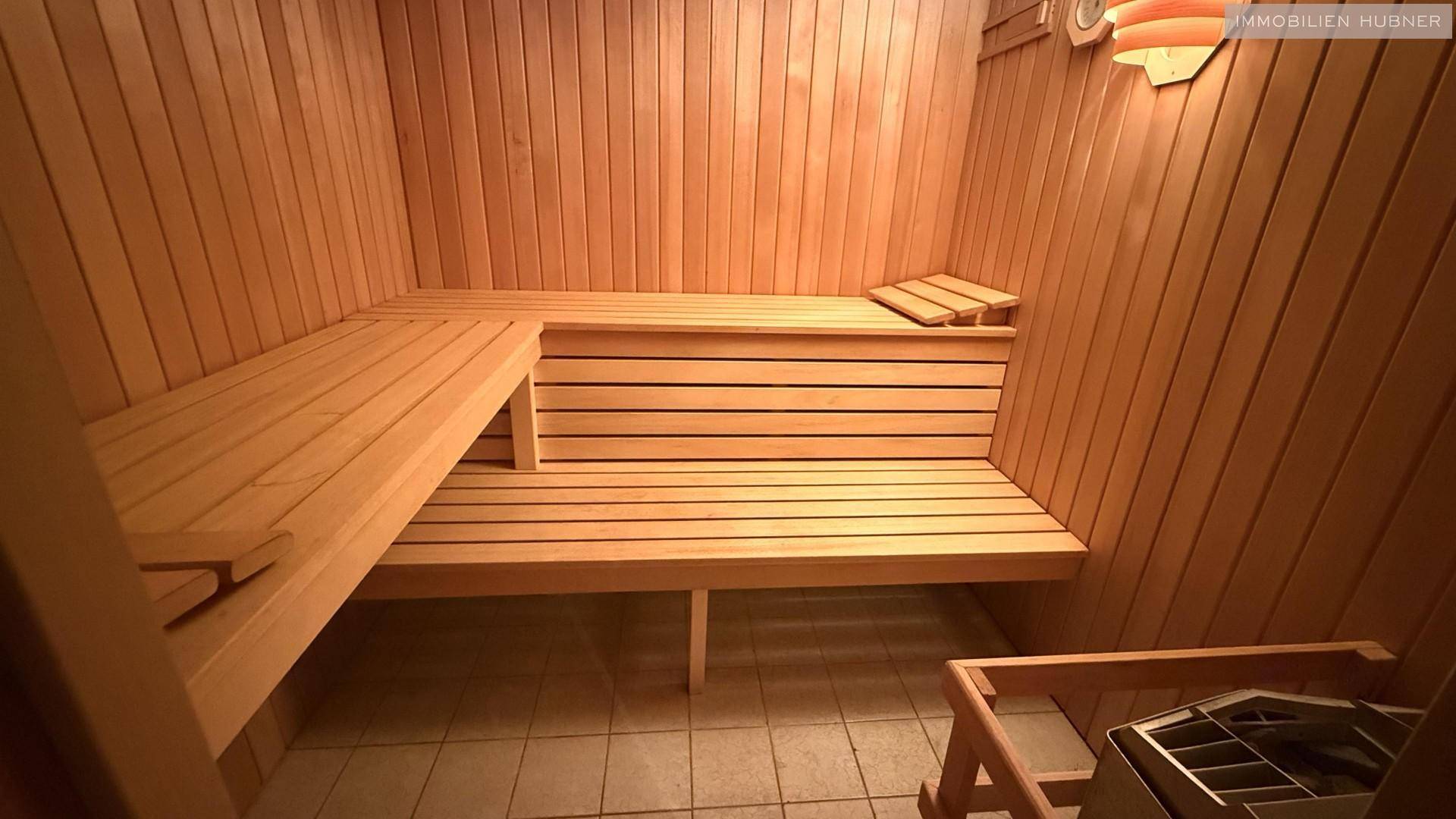 Gemütliche Holzsauna mit mehreren Bänken und traditionellem Saunaofen.