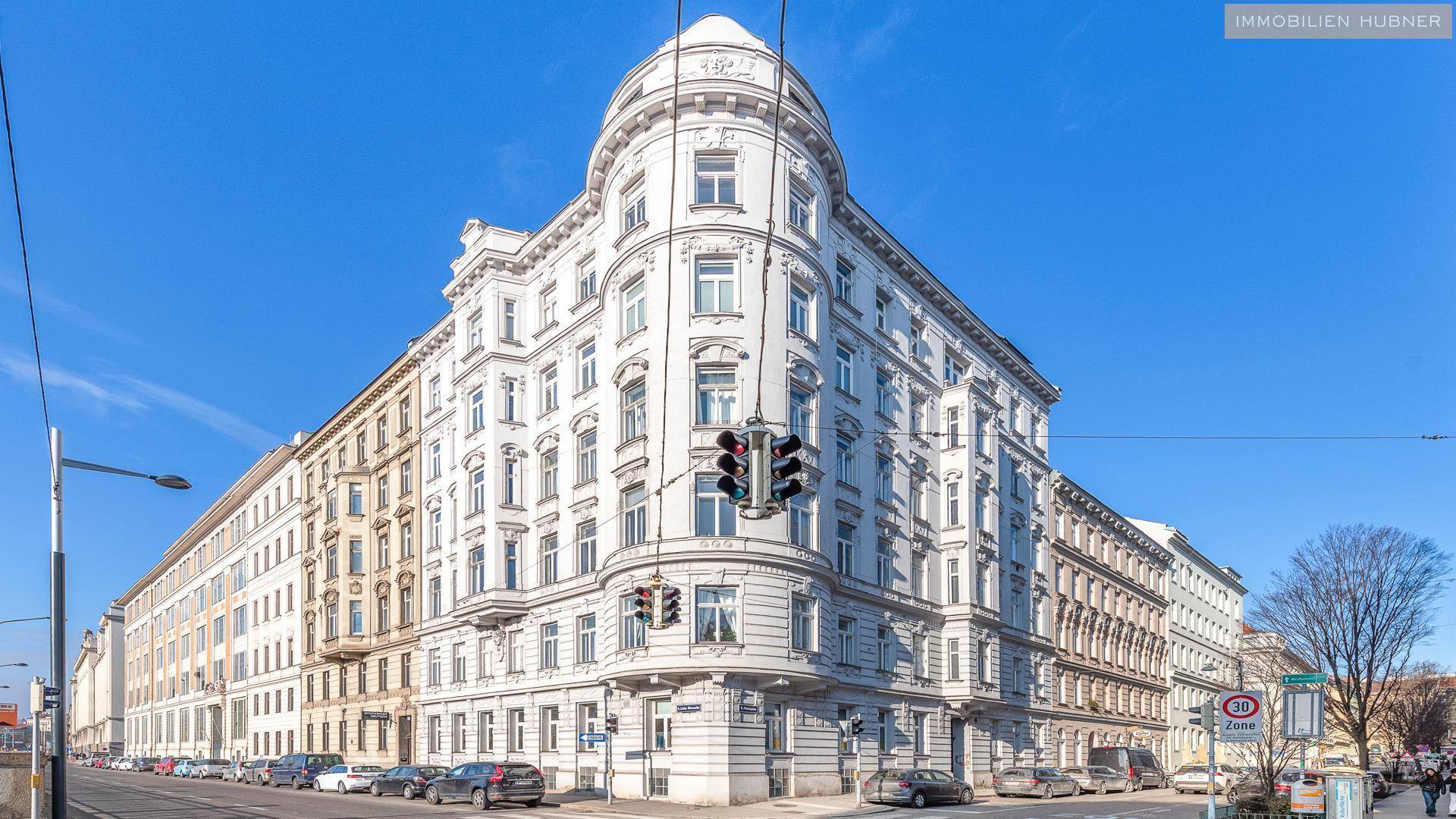 Historisches Eckgebäude mit reich verzierter Fassade und vielen Fenstern in der Stadt.