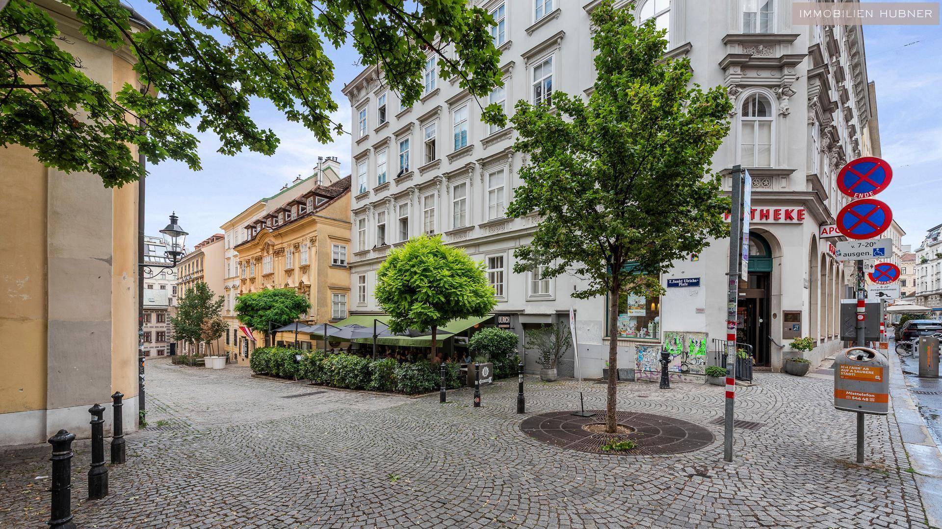 Malerische Straßenecke mit Kopfsteinpflaster, historischen Gebäuden und einem Café mit Außenbereich.
