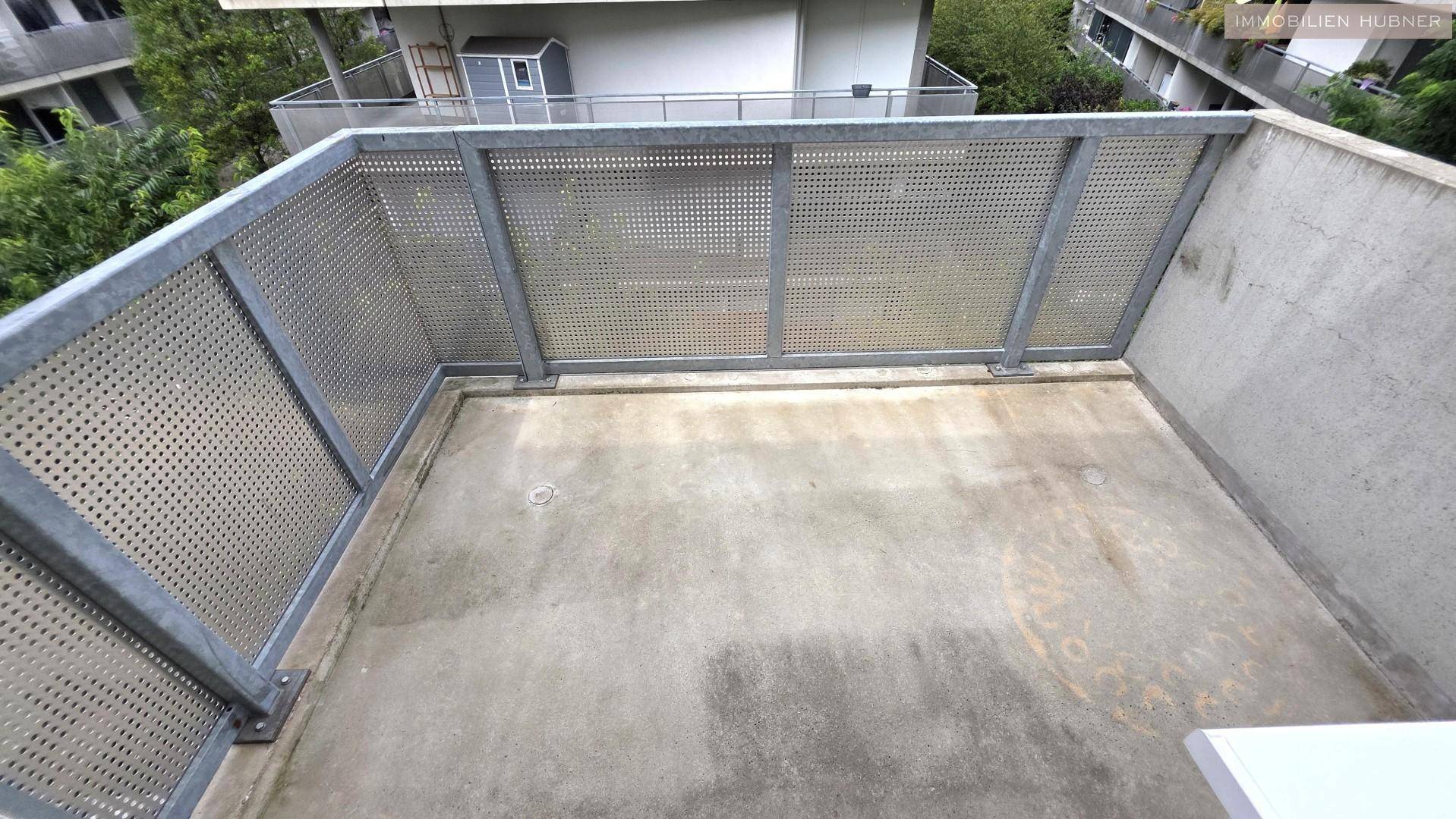 Leerer Balkon mit Metallgeländer und Betonboden, bereit zur individuellen Gestaltung.