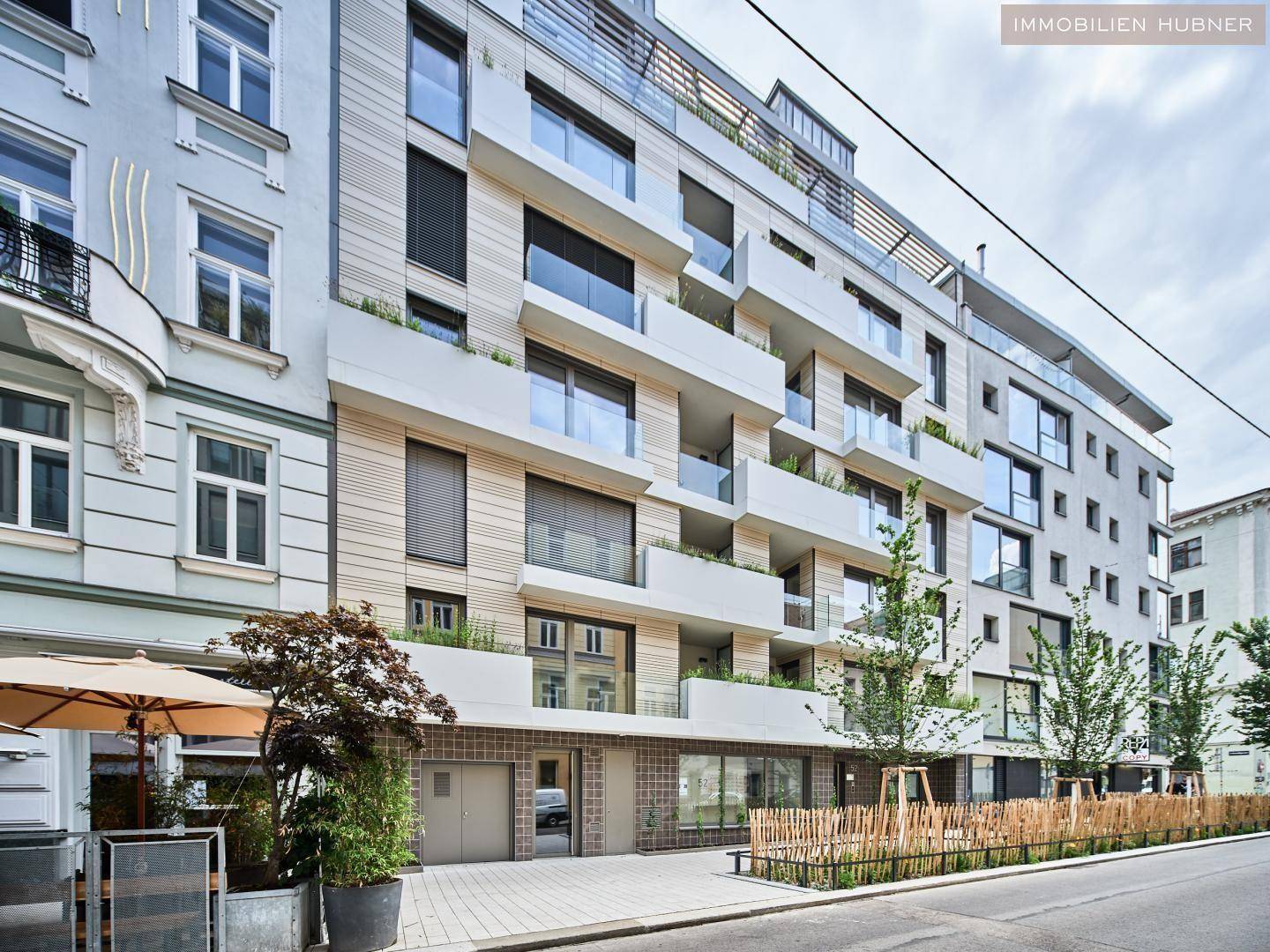 Moderne Wohnhausfassade mit Balkonen, großen Fenstern und ansprechender Architektur.