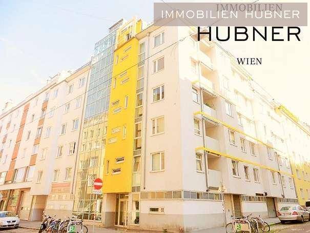 Modernes Wohngebäude mit gelben Akzenten und großen Fenstern in urbaner Umgebung.