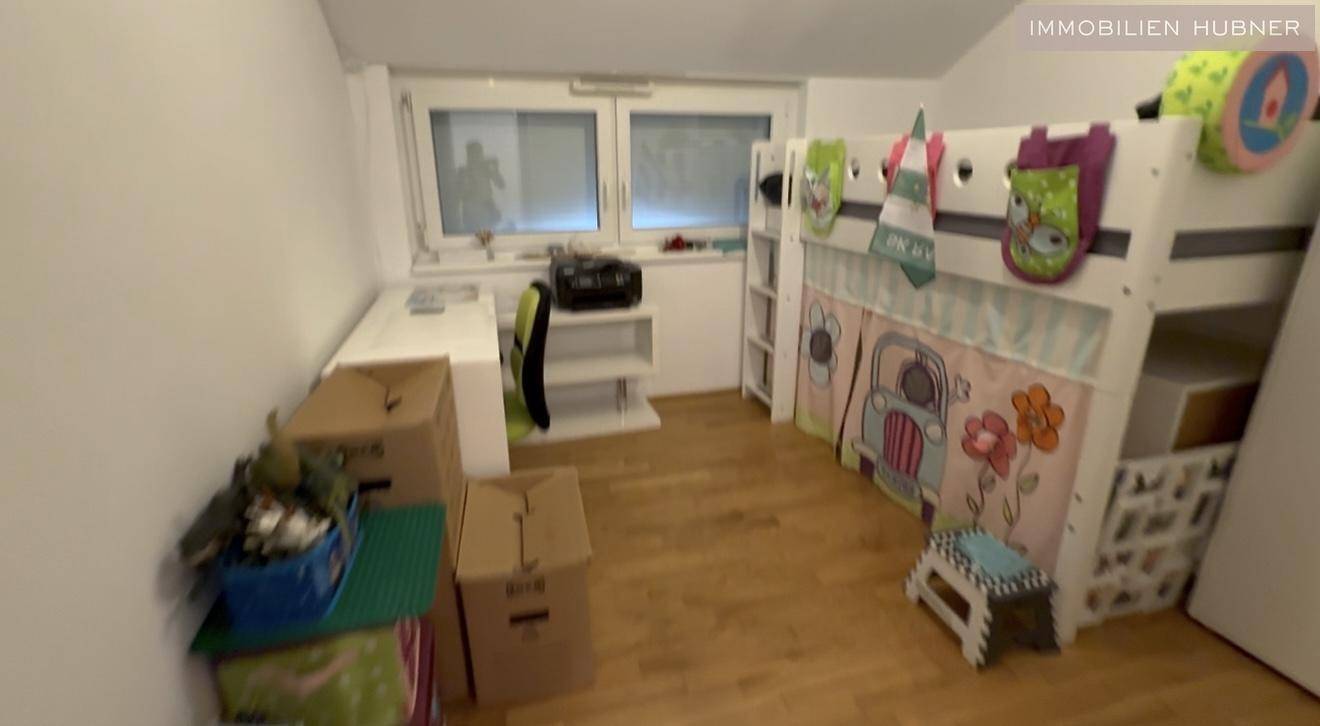 Kinderzimmer mit Hochbett, Schreibtisch und Holzboden.
