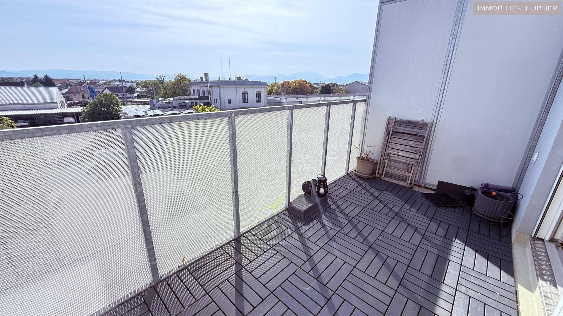 Geräumiger Balkon mit modernen Bodenfliesen und Blick auf die Umgebung.
