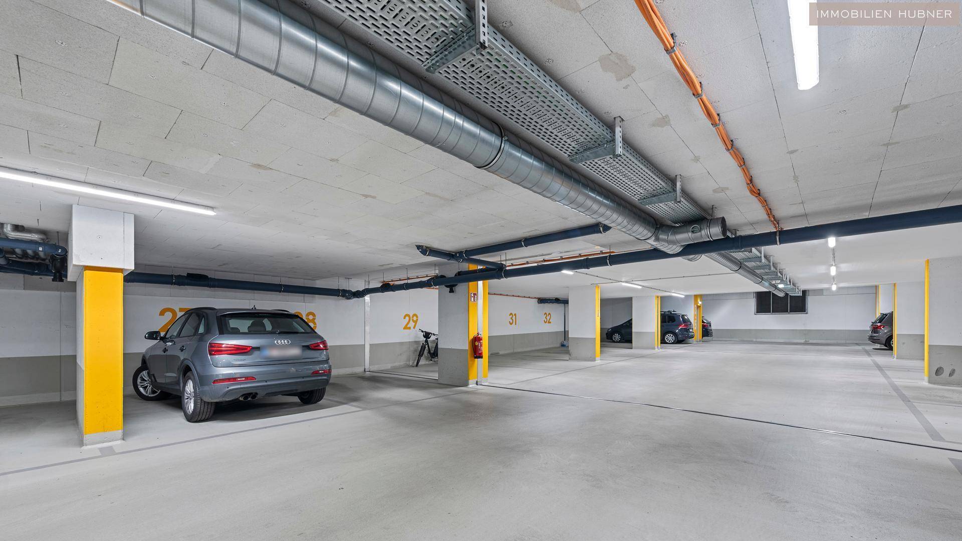 Geräumige Tiefgarage mit markierten Stellplätzen und guter Beleuchtung.