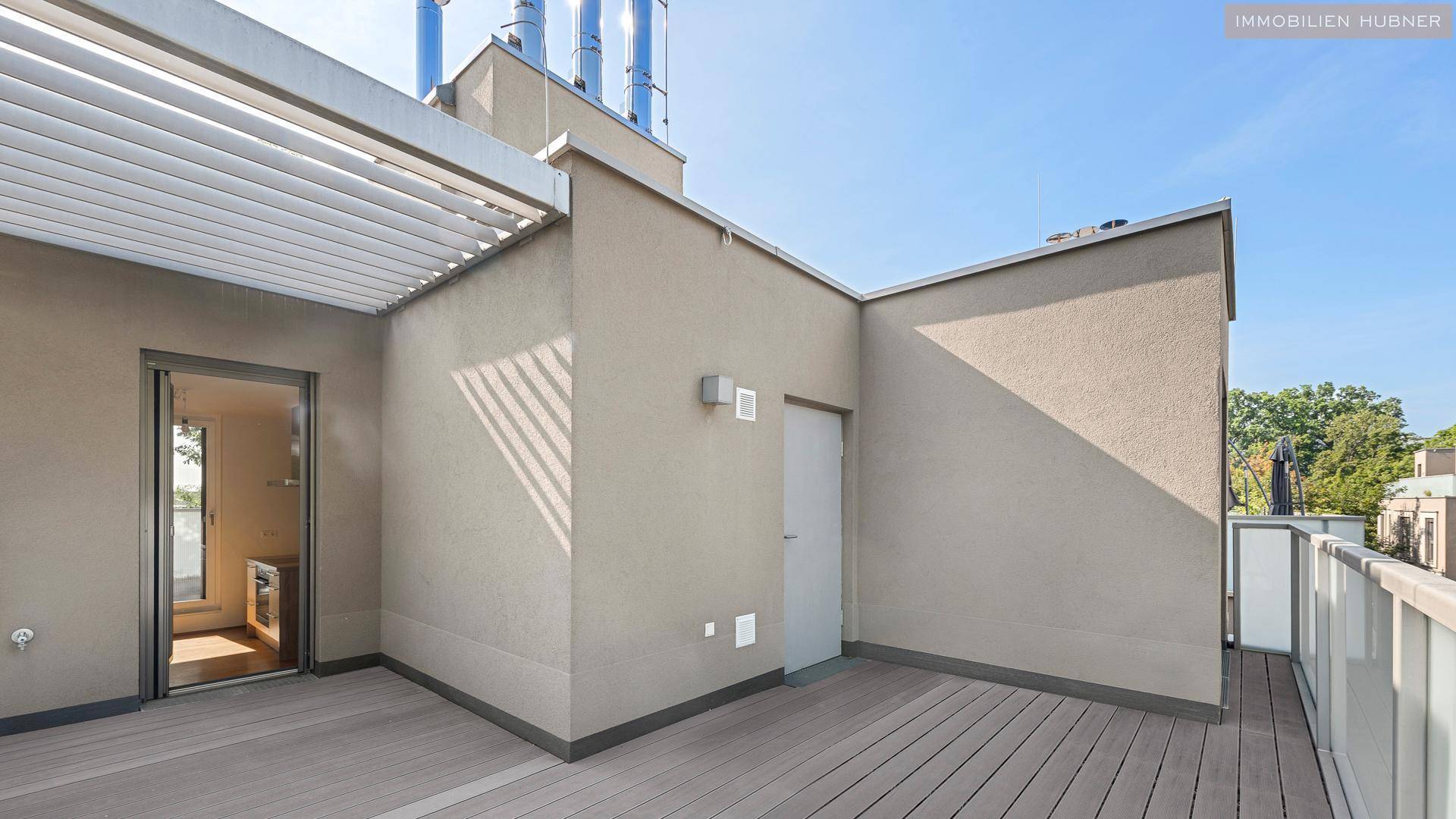 Große Dachterrasse mit Holzboden und Blick auf die umliegenden Gebäude.