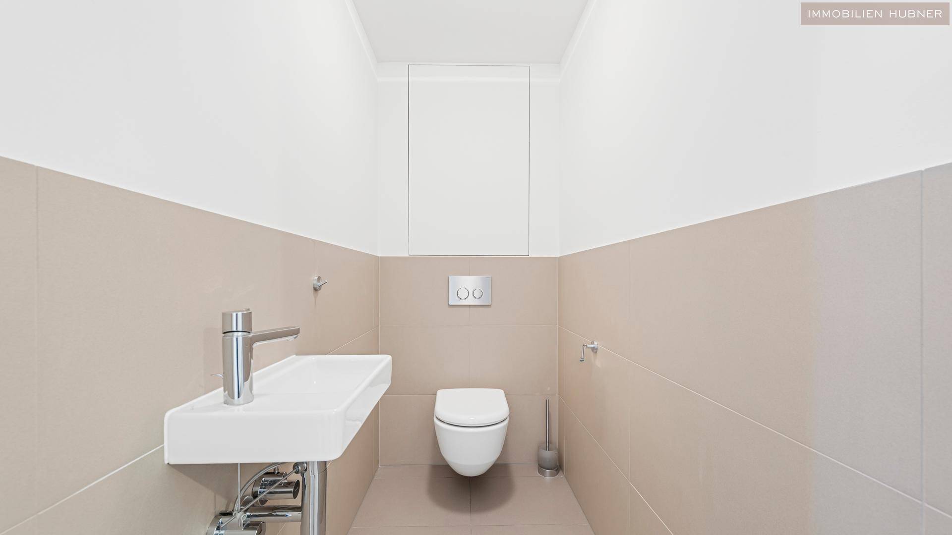 Modernes Gäste-WC mit Wand-WC und kleinem Waschbecken in hellen Farben.