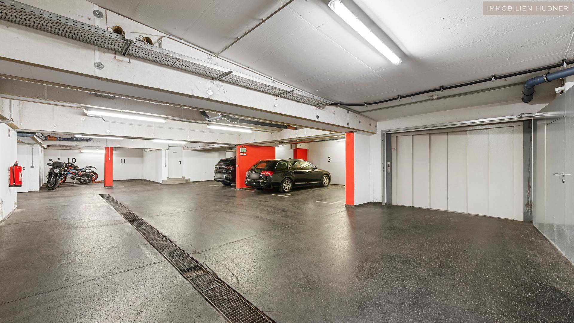 Tiefgarage mit mehreren Stellplätzen und einem Aufzug, der den Zugang erleichtert.