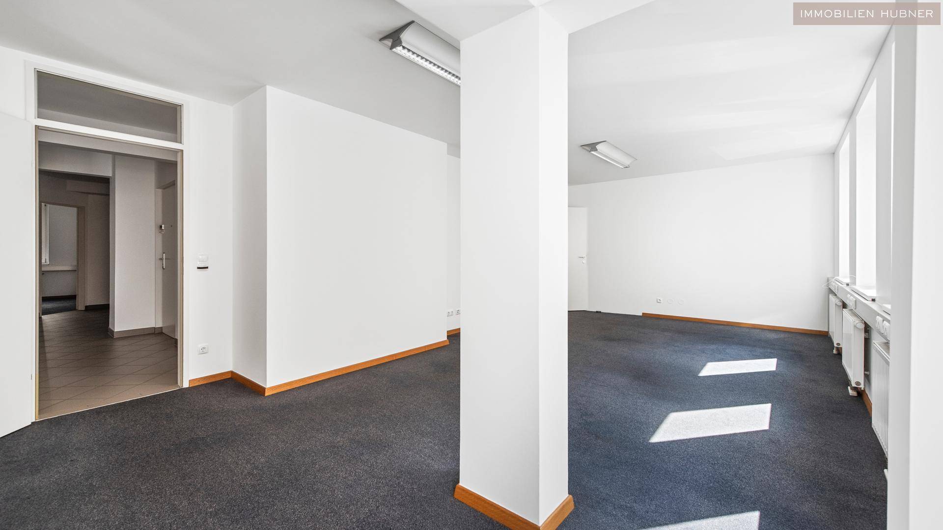 Großer Büroraum mit Teppichboden und Säulen, der vielseitige Gestaltungsmöglichkeiten bietet.