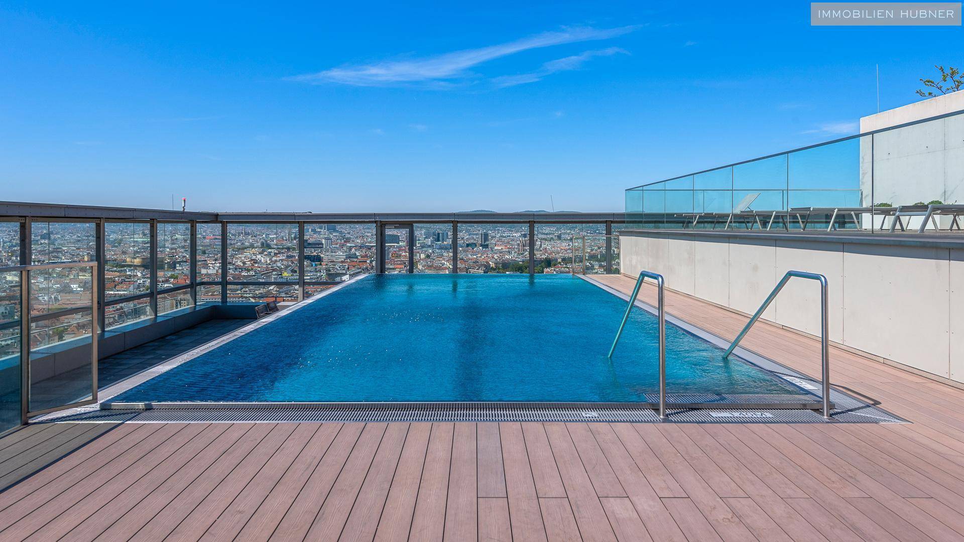 Atemberaubender Infinity-Pool auf dem Dach mit Holzdeck und spektakulärem Panoramablick über die Stadt.
