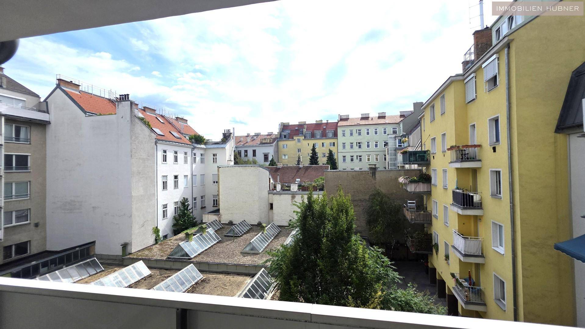Blick auf die umliegenden Wohngebäude und Dächer von einem oberen Stockwerk.