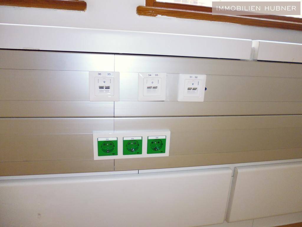 Detailansicht der Wandinstallation mit zahlreichen Steckdosen und Netzwerkanschlüssen.
