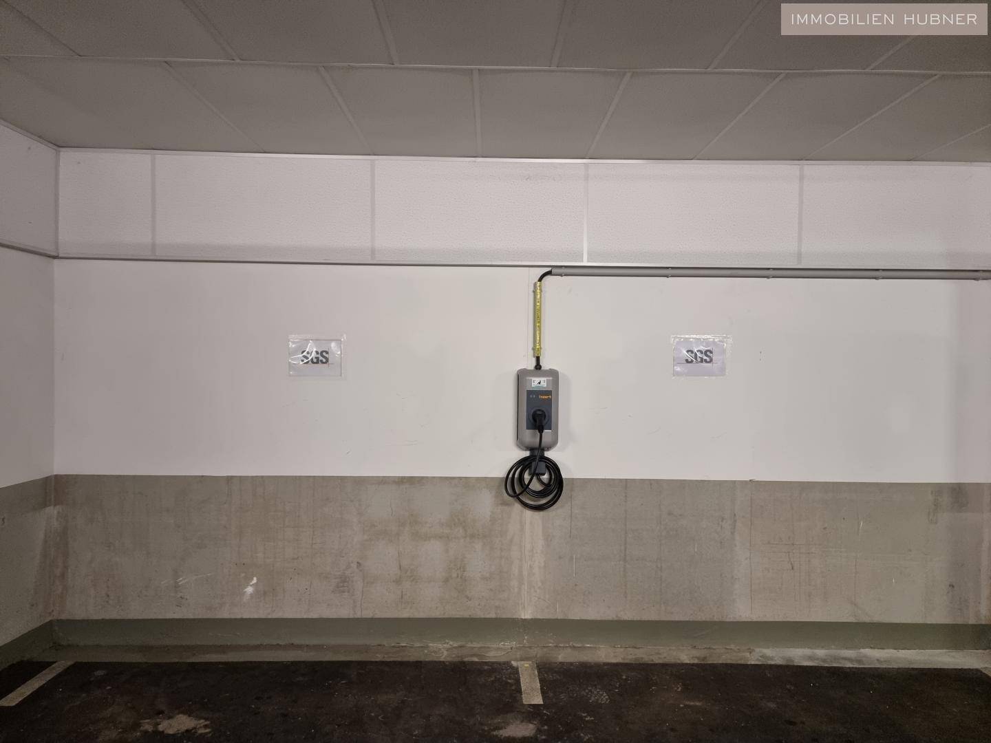 Eine Ladestation für Elektrofahrzeuge in einem Parkplatzbereich.