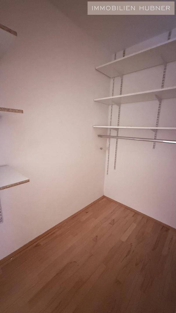 Praktischer Abstellraum mit Regalsystemen für zusätzlichen Stauraum und Holzboden.
