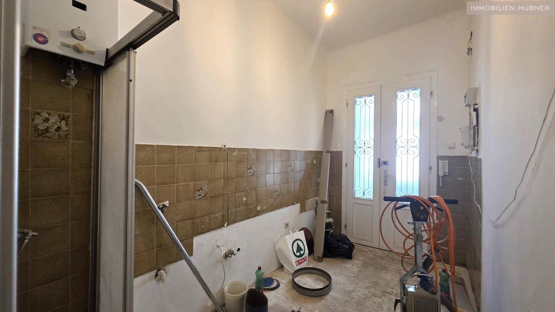 Badezimmer in Renovierung mit alter Duschkabine und Fliesen, bereit für eine Modernisierung.