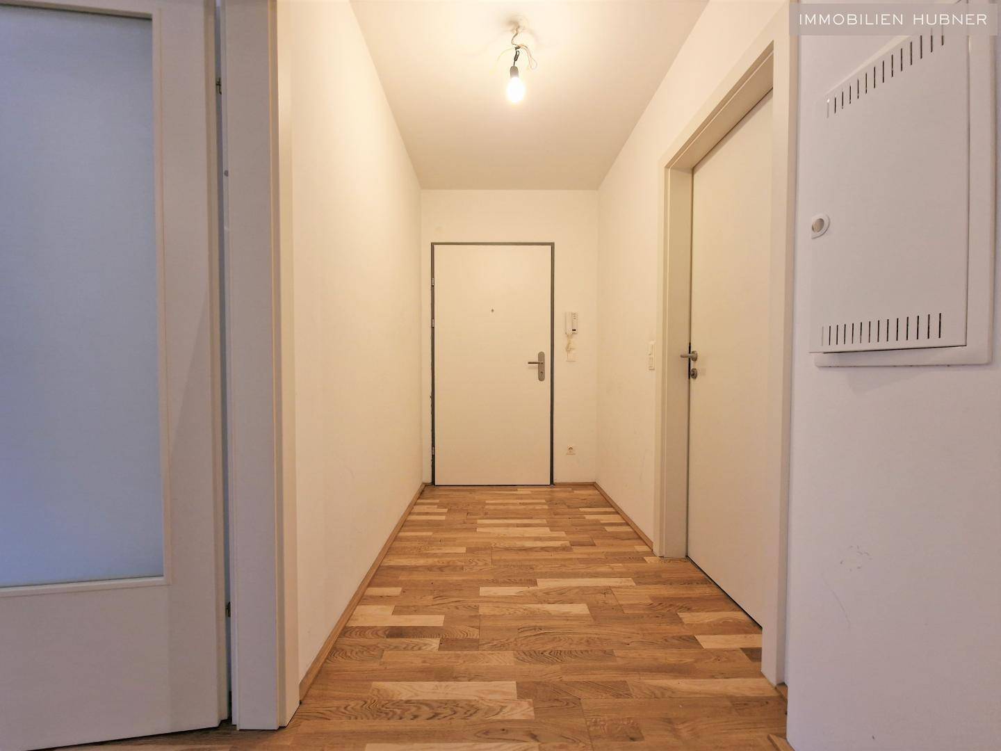 Heller Flur mit Parkettboden und Zugang zu den verschiedenen Räumen der Wohnung.