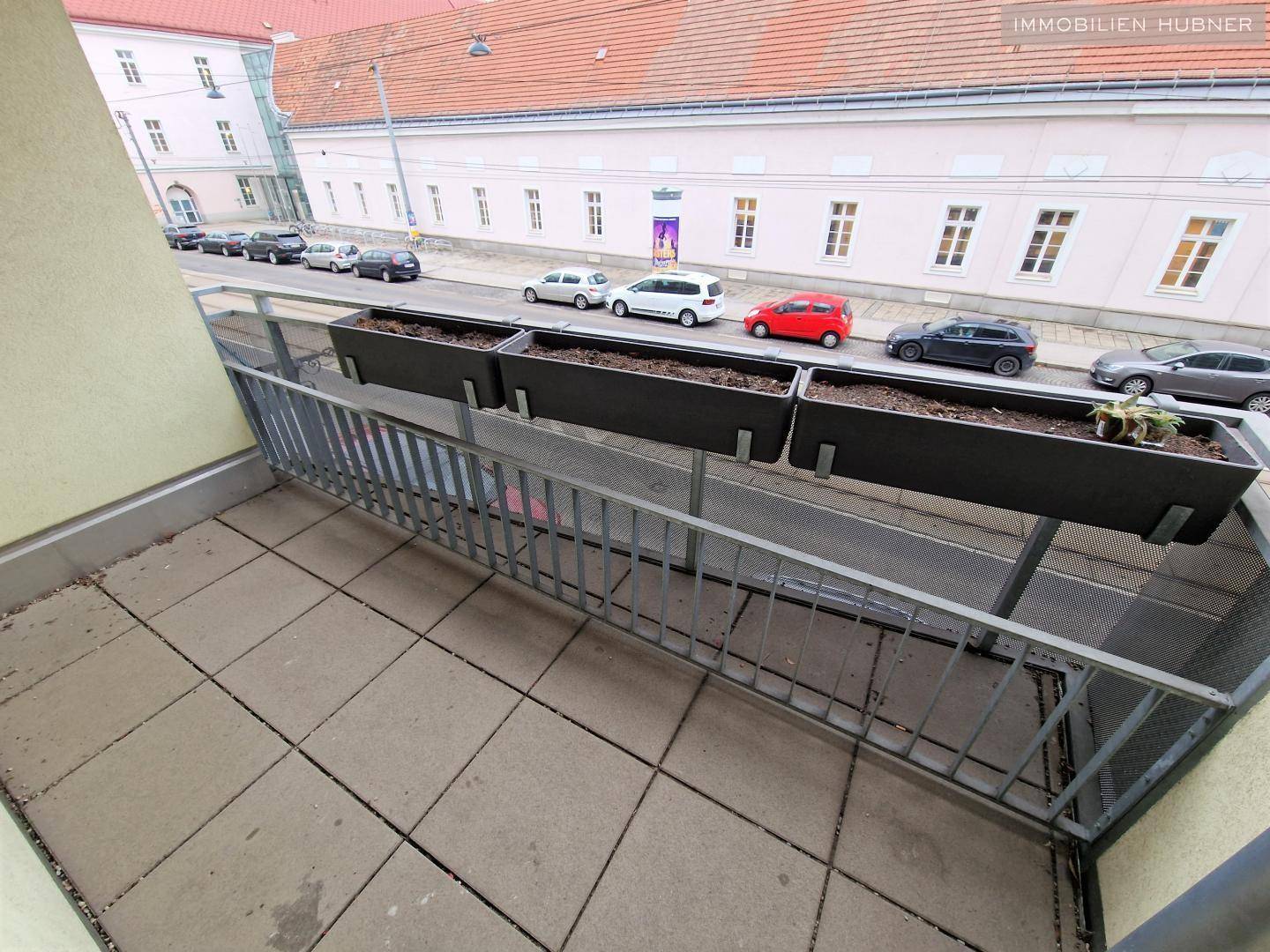 Geräumiger Balkon mit Metallgeländer und Blick auf die umliegende Stadtbebauung.
