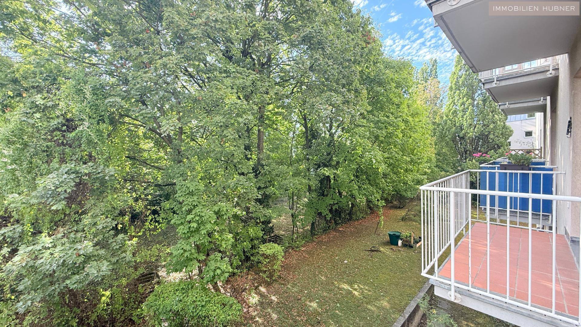 Balkon mit Blick auf einen grünen Gartenbereich und weitere Balkone.