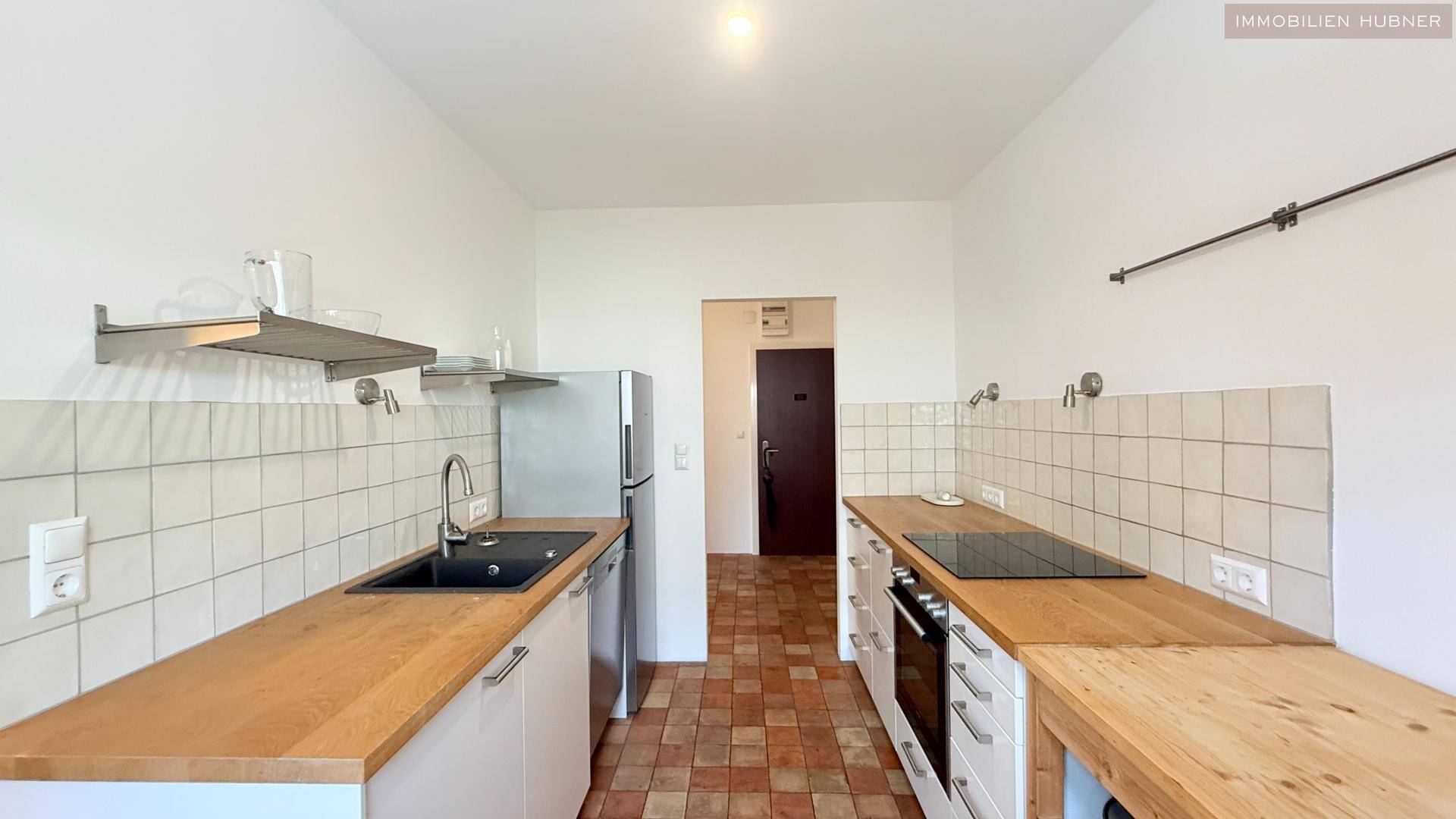 Geräumige Küche mit modernen Geräten und Terrakotta-Fliesenboden.