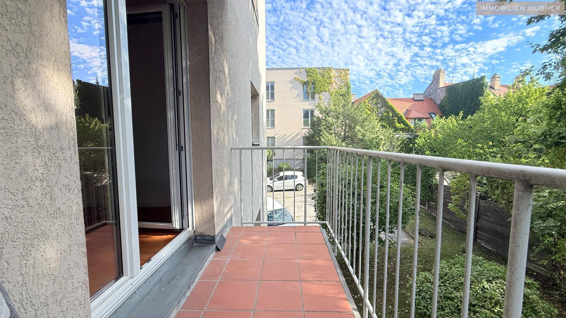 Balkon mit Terrakotta-Fliesenboden und Blick auf die Umgebung.
