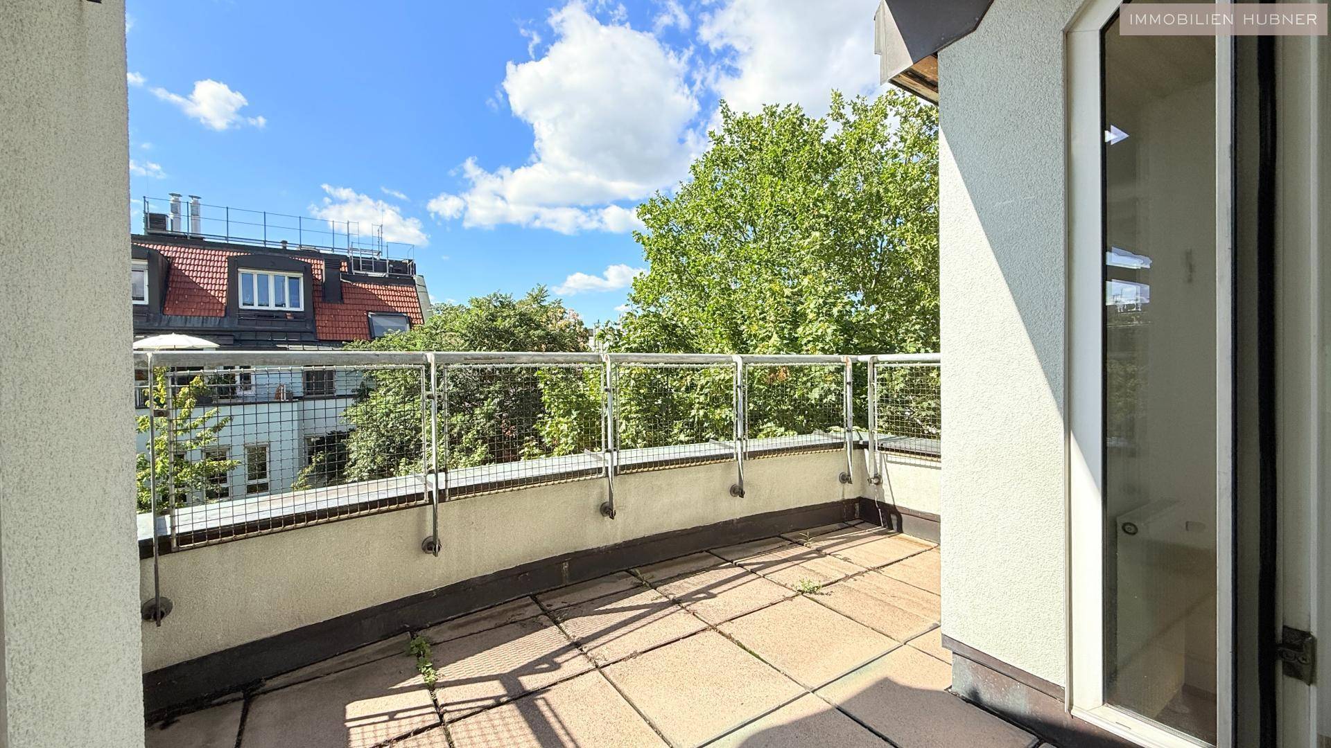 Geräumiger Balkon mit Fliesenboden und Metallgeländer, bietet einen weiten Blick über die Umgebung.