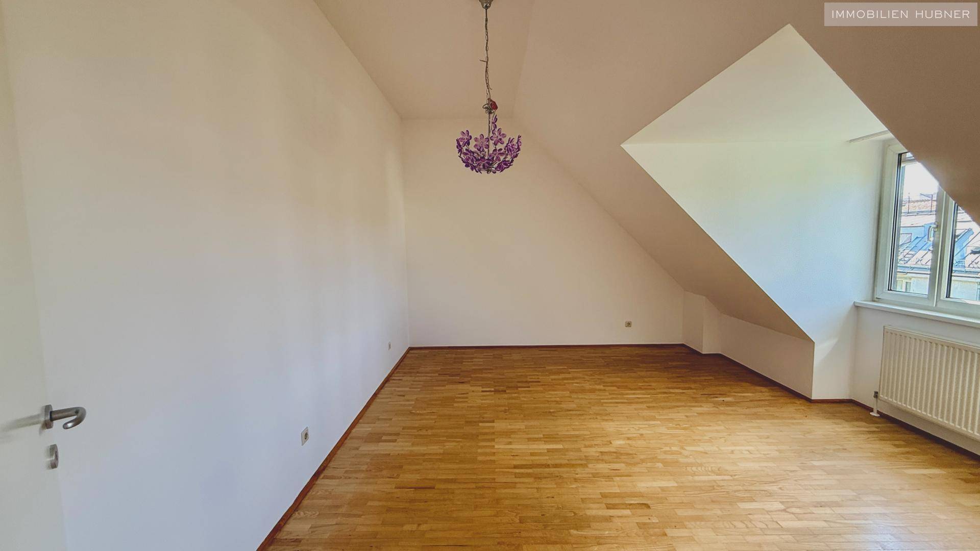 Schlafzimmer im Dachgeschoss mit Holzboden und Dachschrägen, bietet eine gemütliche Atmosphäre.