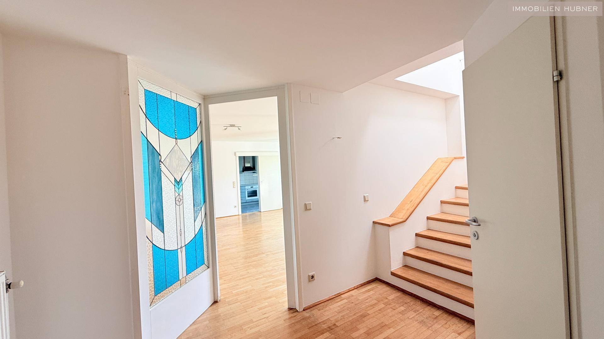 Eingangsbereich mit Holzboden und einer Treppe, die in die obere Etage führt.