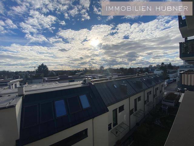 Weitblick über die Dächer der Stadt unter einem blauen Himmel mit Wolken.