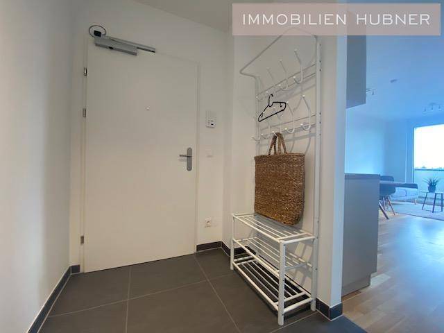 Heller Eingangsbereich mit Fliesenboden und Garderobe.