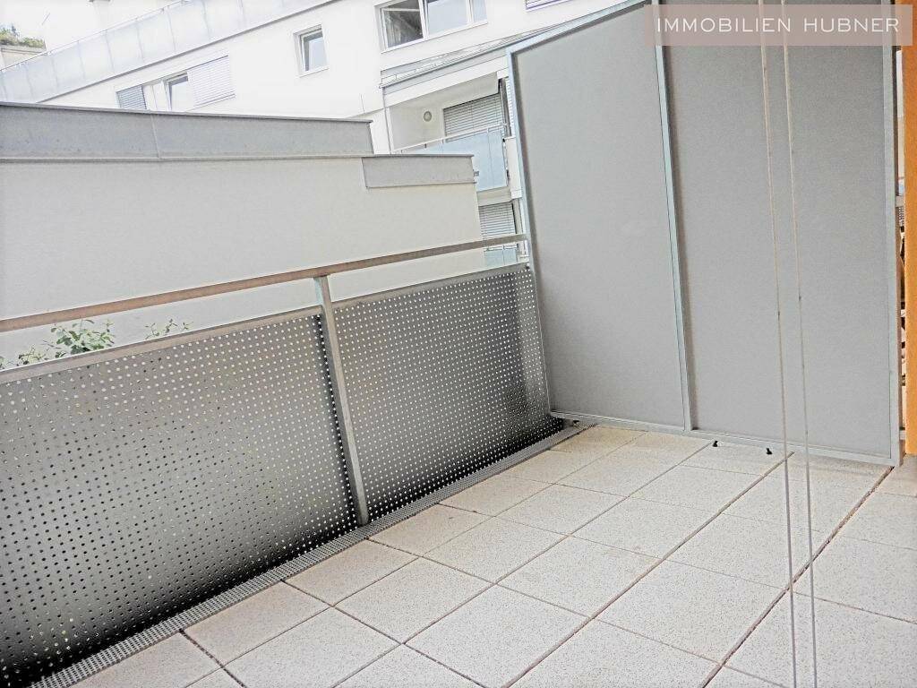 Heller Balkon mit Fliesenboden und Metallgeländer, bietet Platz für eine Sitzgelegenheit.