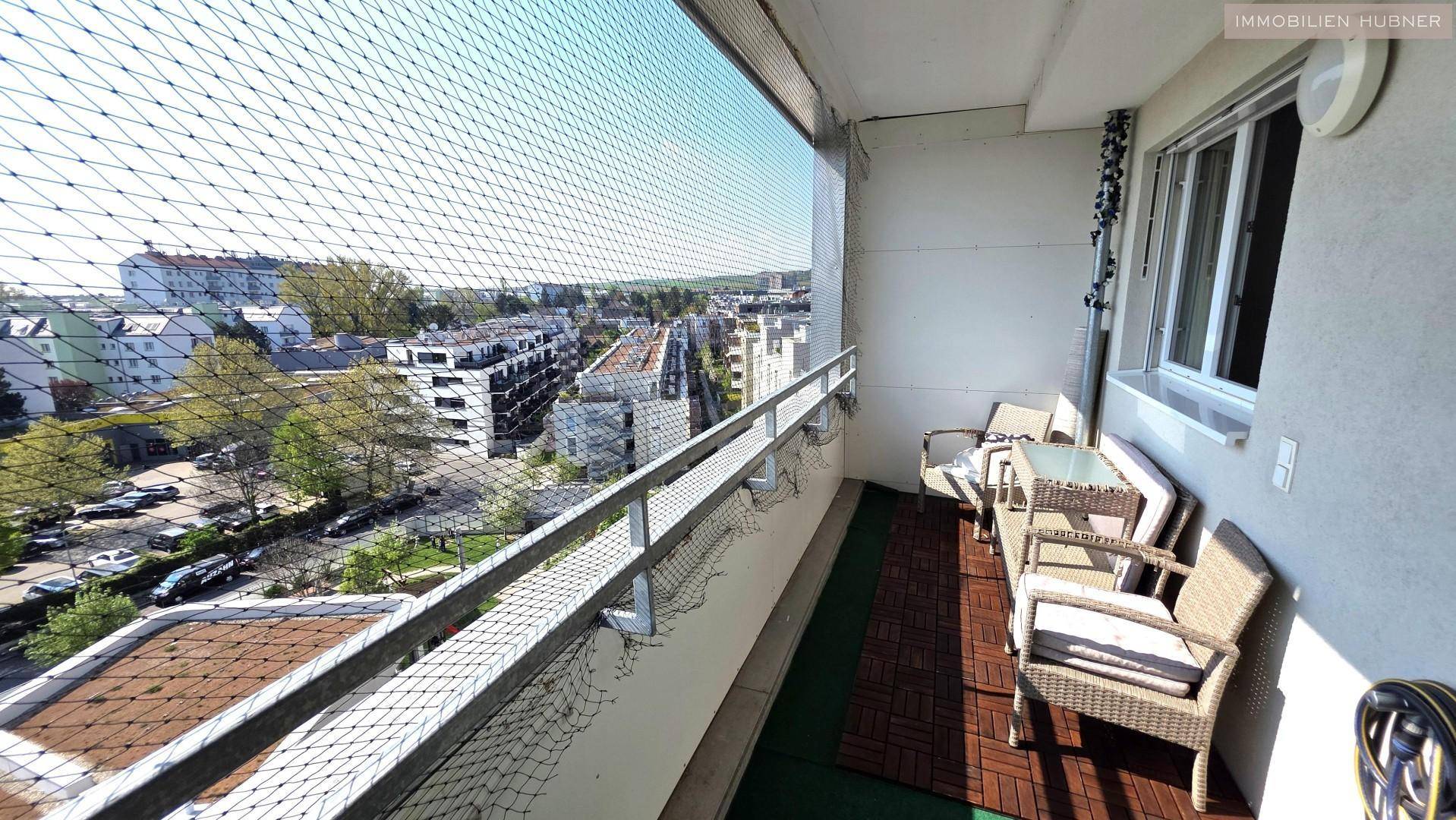 Möblierter Balkon mit Sitzgelegenheiten und weitem Blick über die Stadt.